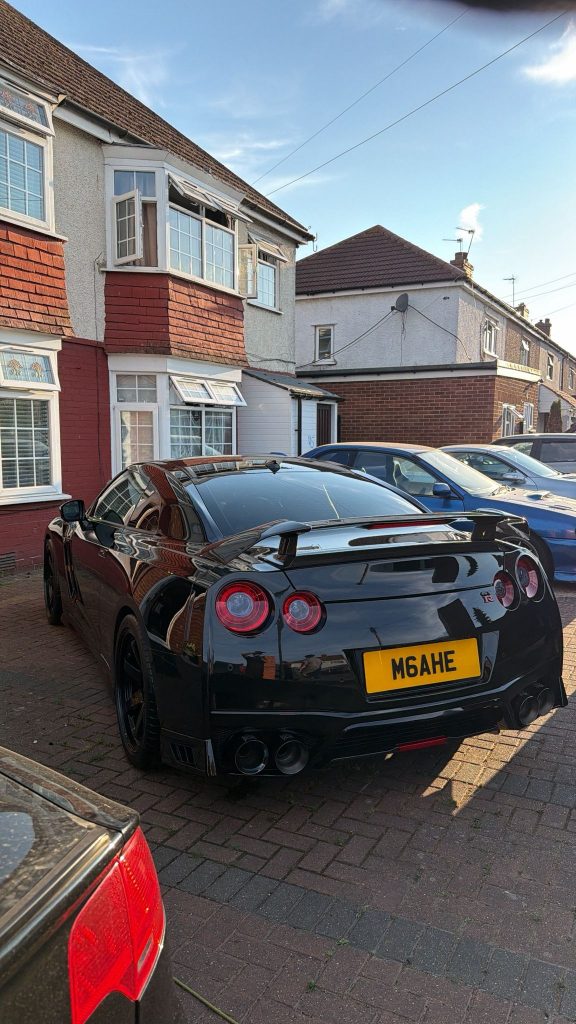 Black Nissan GT-R photographed from the rear three-quarter, paintwork gleaming after a full detail